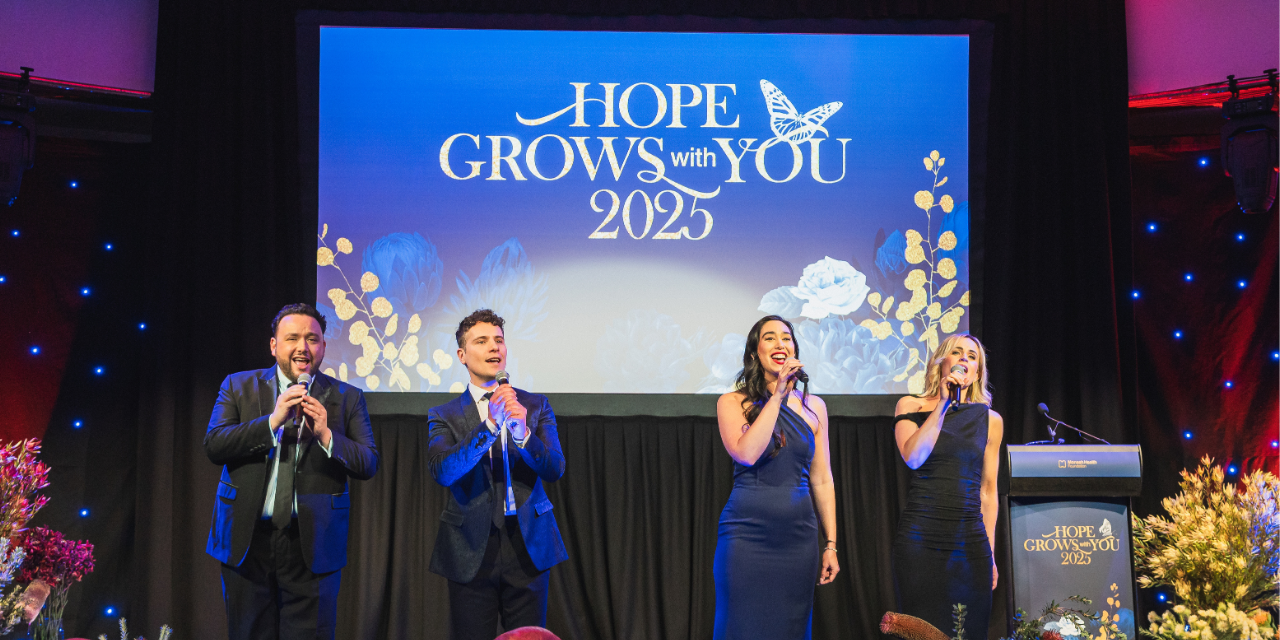 Four people singing at an event