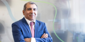 Professor Arvind Sehgal smiles toward camera with arms crossed