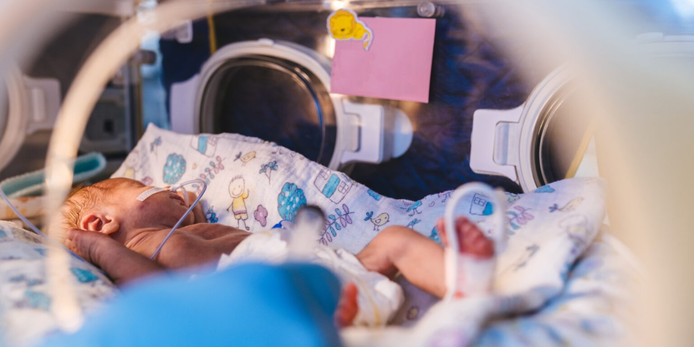 Premature newborn rests inside incubator