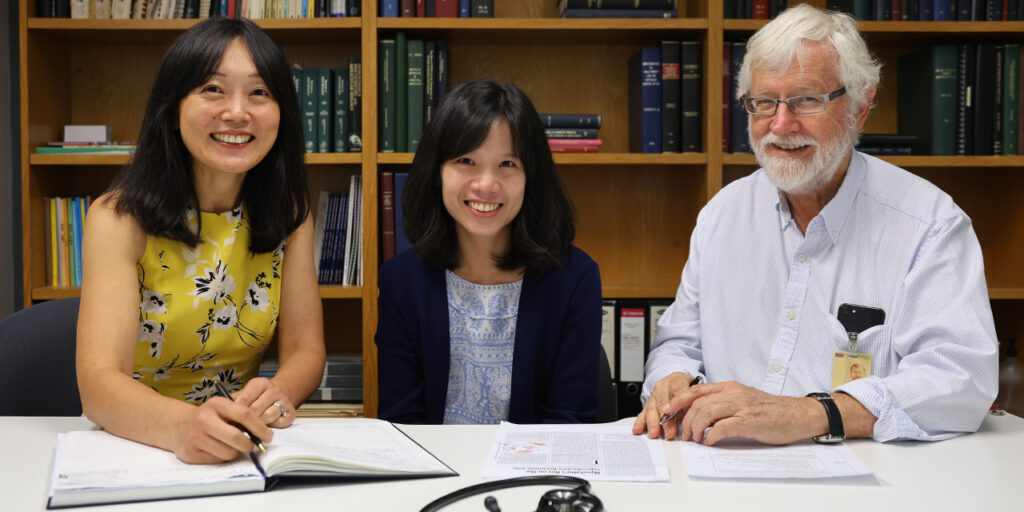 Photo of A/Prof Jun Yang, Dr Renata Libianto, and Prof Peter Fuller. sitting at a table with a bookshelf behind them