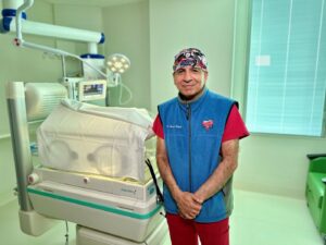 Medical professional standing beside an incubator in a hospital room