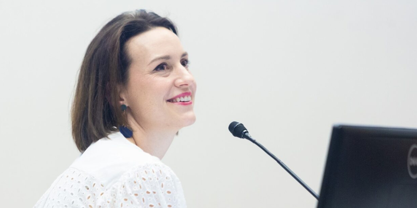 A woman presenting at a lectern